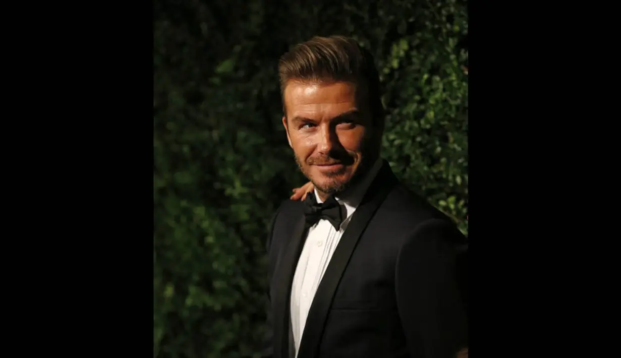 David Beckham terlihat tampan dengan setelan jas berwarna biru tua lengkap dengan dasi kupu-kupu hitam di London, Minggu (30/11/2014). (AFP PHOTO/Justin Tallis)