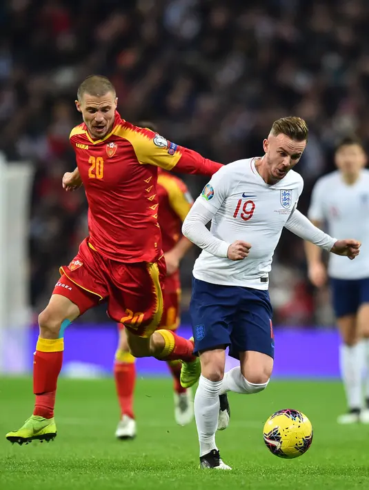 Gelandang Inggris James Maddison (kanan) menggiring bola dari kejaran bek Montenegro, Aleksandar Sofranac pada pertandingan Grup A Kualifikasi Piala Eropa 2020 di Stadion Wembley di London (14/11/2019). Inggris menang telak 7-0 atas Montenegro. (AFP/Glyn Kirk)