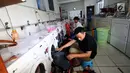 Sejumlah pekerja mengambil pakaian yang telah di cuci menggunakan mesin cuci di Bogor Laundry, Bogor, Kamis (28/9). Bisnis laundry tersebut dapat meraih keuntungan perhari hingga 10 juta. (Liputan6.com/Angga Yuniar)