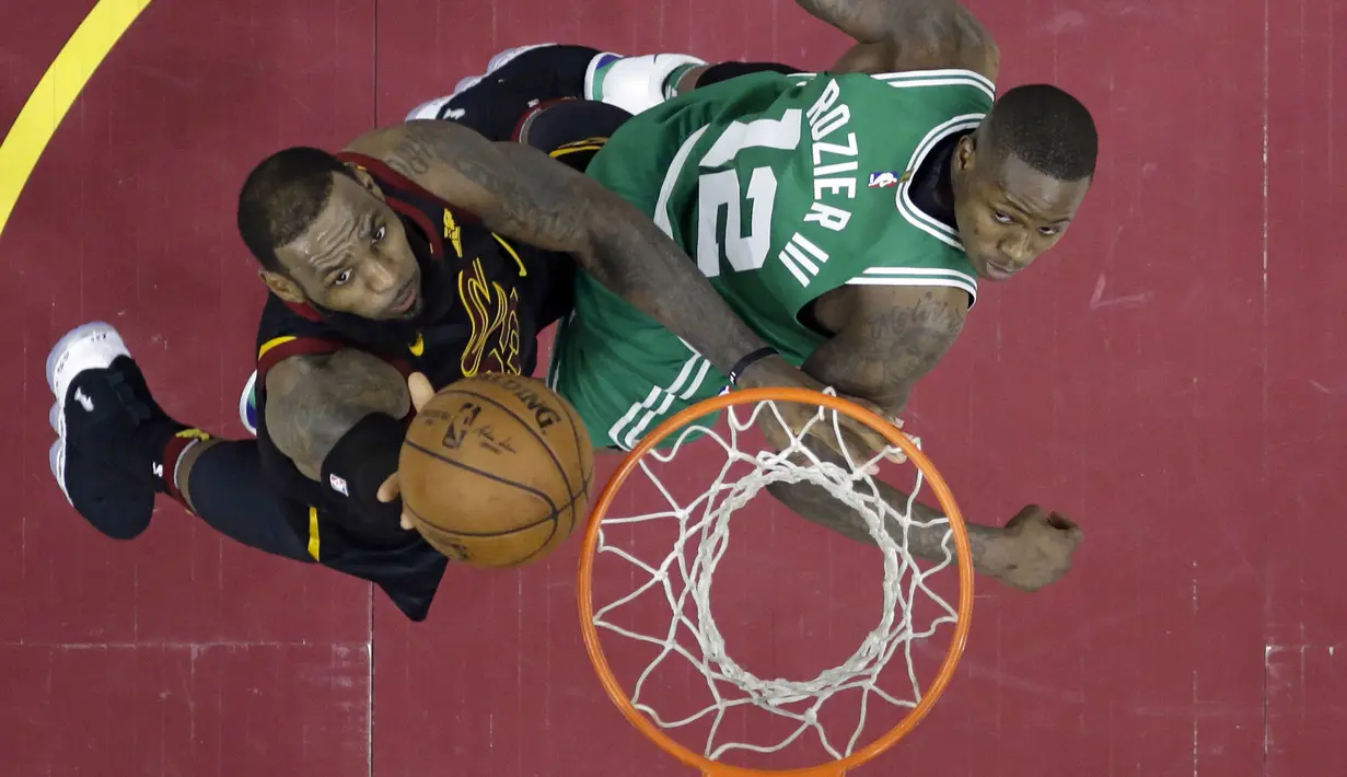 LeBron James (kiri) berusaha memasukan bola saat diadang pemain Celtics, Terry Rozier pada laga final Wilayah Timur NBA basketball di Quicken Loans Arena, Clevelan, (19/5/2018). Cavaliers menang 116-86. (AP/Tony Dejak)