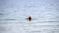 Seorang pria berenang di laut Baltik di Gdynia, Polandia utara (24/5/2019). Dalam bahasa Jerman, laut ini disebut Ostsee yang sebenarnya berarti "laut Timur". (AP Photo/Darko Vojinovic)