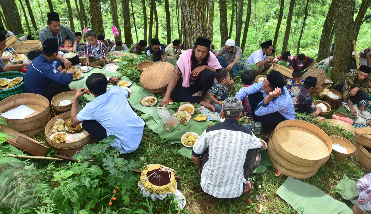 Warga mengikuti prosesi Sadranan Asyura di makam kiai kramat di bukit Tlogo Pucang, Kandangan, Temanggung, Rabu  (12/10).  Warga berdatangan sambil membawa tenongan berisi makanan yang didoakan dan kemudian di makan bersama. (Liputan6.com/Gholib)