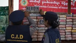 Aparat kepolisian Myanmar memeriksa narkotika sitaan sebelum acara pemusnahan pada Hari Antinarkoba Sedunia, di Yangon, Senin (26/6). Myanmar membakar opium, heroin, dan kokain senilai sekitar US$385 juta, setara Rp5,1 miliar. (AP Photo/Thein Zaw)