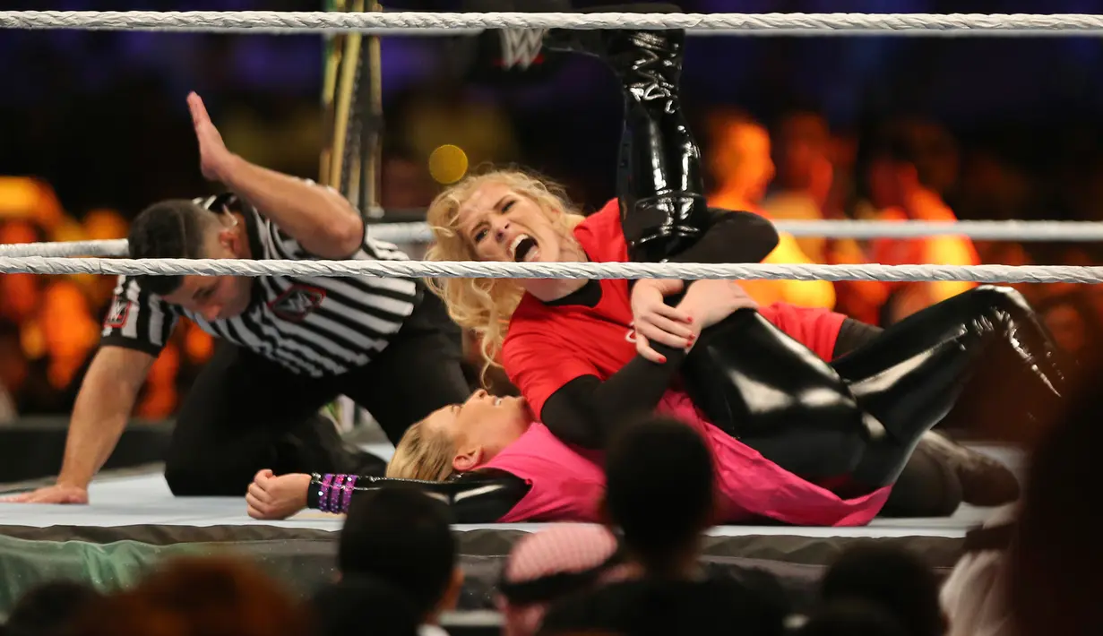 Pegulat Lacey Evans berusaha mengunci lawannya, Natalya Neidhart pada pertarungan World Wrestling Entertainment (WWE) untuk perempuan di Stadion Internasional King Fahd, Riyadh, 31 Oktober 2019. Kerajaan Arab Saudi untuk pertama kalinya menggelar pertandingan gulat WWE perempuan. (AP/Amr Nabil)