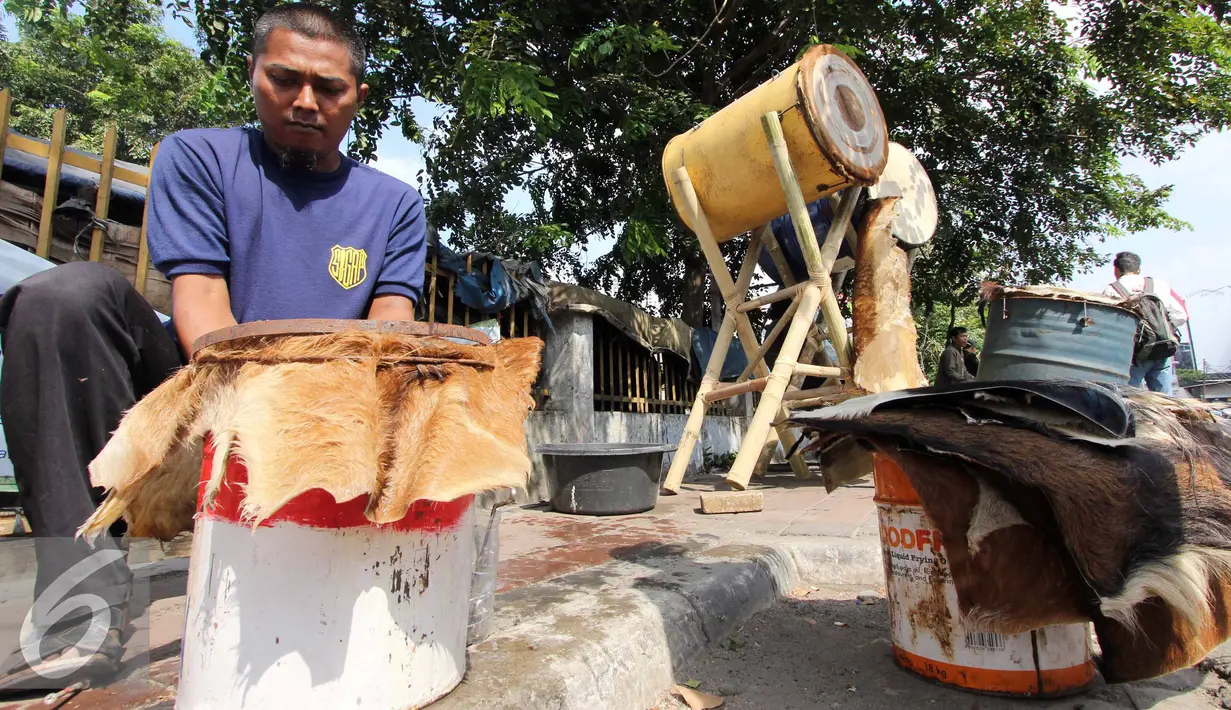 Seorang pedagang bedug tampak memperbaiki bedug dagangannya, Tanah Abang, Jakarta, Kamis,(16/7/2015). Harga bedug berkisar Rp.200-700 Ribu tergantung ukuran. (Liputan6.com/Helmi Afandi)