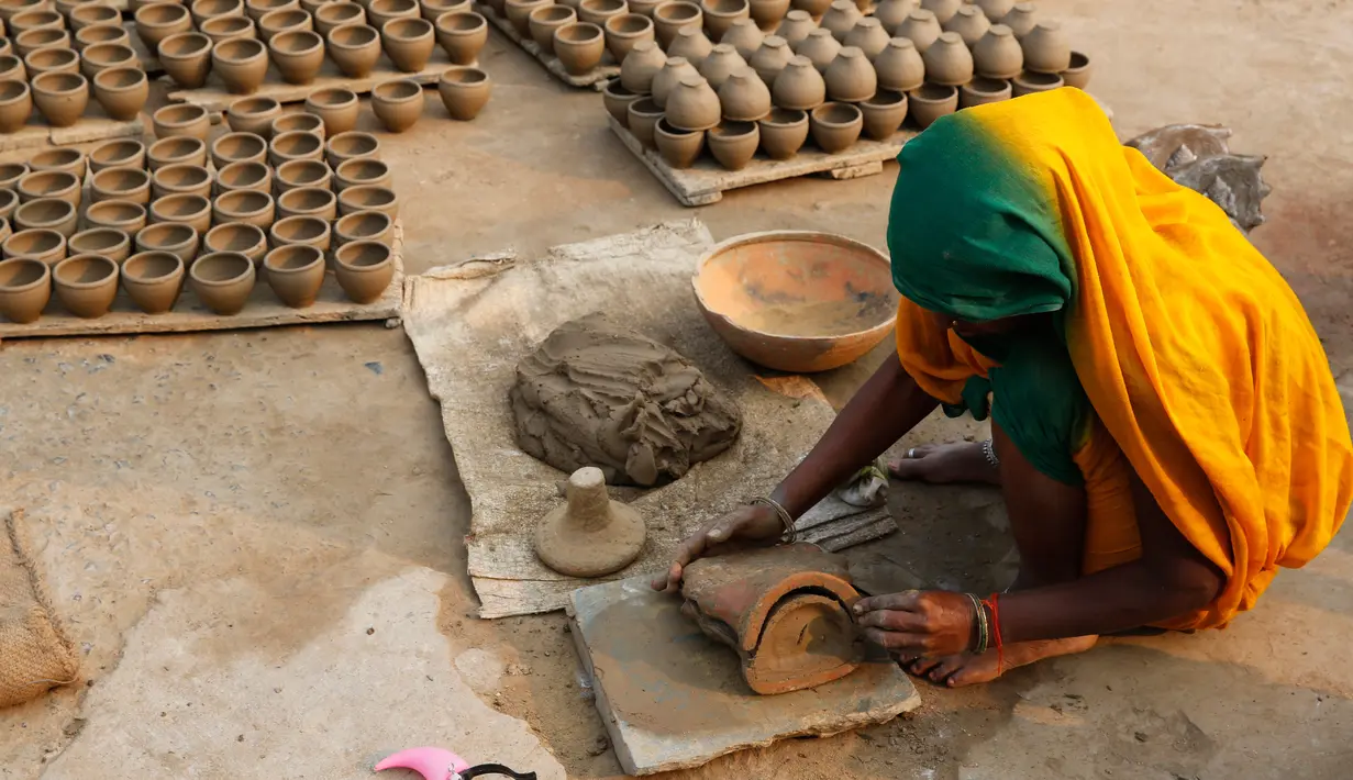 Pengrajin tembikar menyiapkan lampu minyak yang terbuat dari tanah liat menjelang festival Diwali di Prayagraj, India, Kamis (17/10/2019).  Diwali atau Deepavali merupakan festival lampu yang penting bagi umat Hindu di seluruh dunia. (AP/Rajesh Kumar Singh)