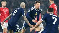 Gelandang Skotlandia #04 Scott McTominay (tengah) merayakan gol pembuka dalam pertandingan kualifikasi Piala Dunia 2026 zona Eropa antara Skotlandia dan Denmark di Hampden Park, Glasgow, Rabu (19-11-2025) dini hari WIB. (ANDY BUCHANAN/AFP)