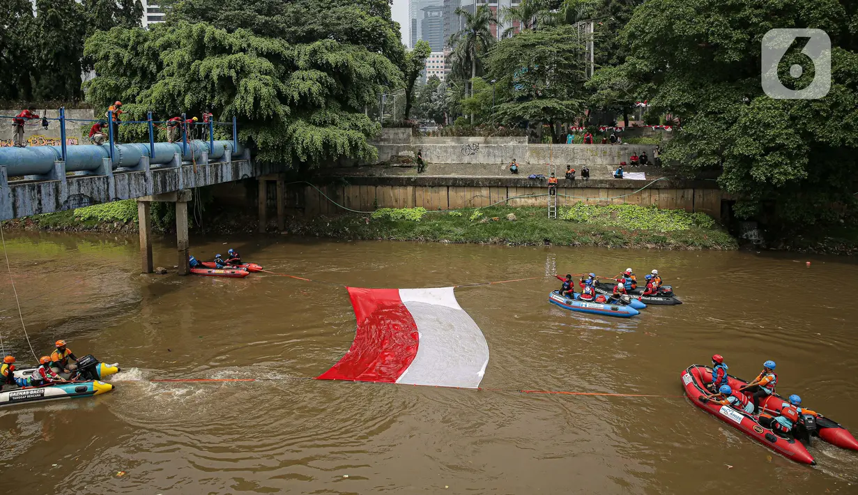Sejumlah relawan membentangkan bendera Merah Putih di aliran kali
Ciliwung di kawasan Sudirman, Jakarta, Minggu (22/8/2021). Pembentangan atau pengibaran bendera Merah Putih tersebut dilaksanakan untuk memperingati HUT ke-76 RI. (Liputan6.com/Faizal Fanani)