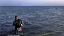 Seorang imigran Mali berjalan usai ia dan tujuh lainnya mendayung melintasi Laut Aegea antara Turki dan Yunani pada, (8/8/2015). PBB dan UNHCR memperkirakan bahwa Yunani telah menerima lebih dari 107.000 pengungsi. (REUTERS/Yannis Behrakis)