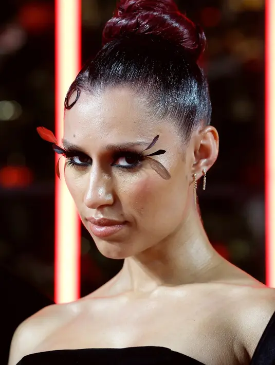 Raye membuat pernyataan dengan bulu mata OTT. Dan lihat bagaimana ia menata rambutnya dengan gaya slick black cherry bun.