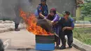 Warga dibantu petugas Damkar mencoba memadamkan api menggunakan karung basah di Rusun Jatinegara Barat, Jakarta, Senin (14/9/2015). Pelatihan dan simulasi ini guna mengantisipasi penanganan sejak dini tindak kebakaran. (Liputan6.com/Gempur M Surya)