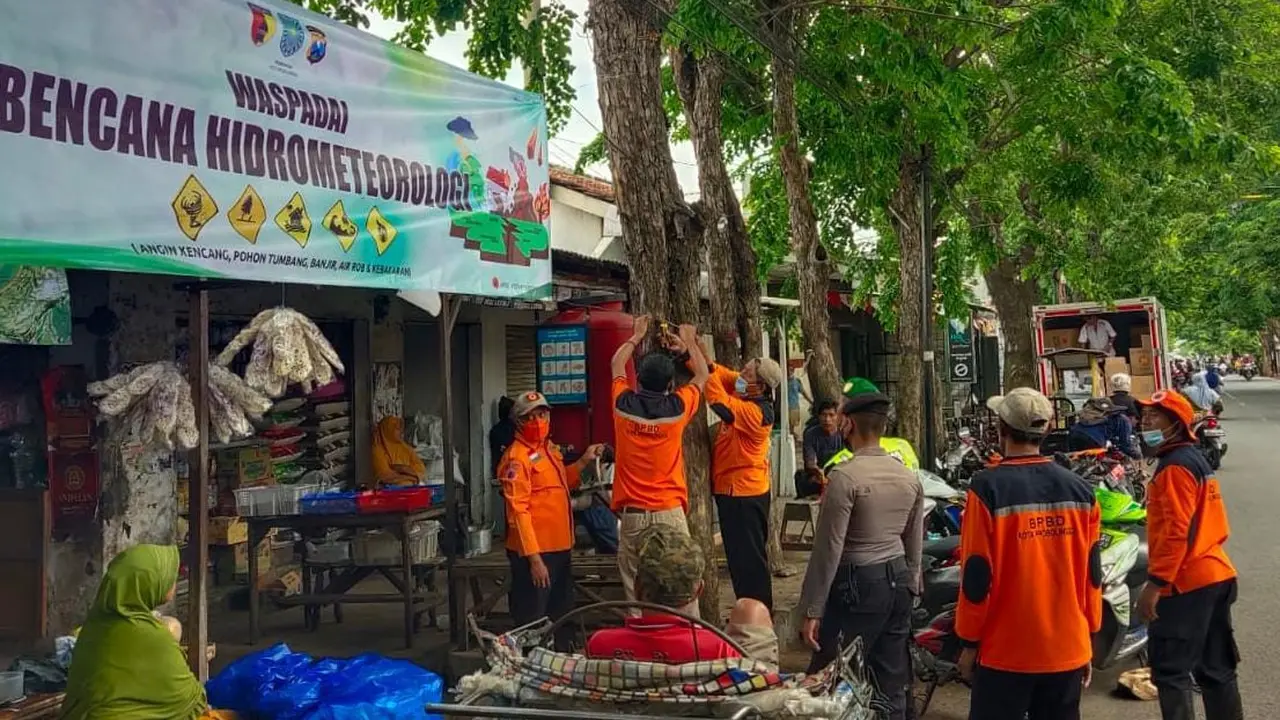 Anggota BPBD Probolinggo Kota pasang bener himbauan waspada bencana alam di sejumlah sudut kota (Istimewa)