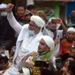 Rizieq Shihab menyapa massa pendukungnya saat tiba di kediamannya di Jalan Petamburan, Jakarta, Selasa (10/11/2020). Rizieq Shihab tiba di kediamannya usai pulang dari Arab Saudi. (merdeka.com/Imam Buhori)