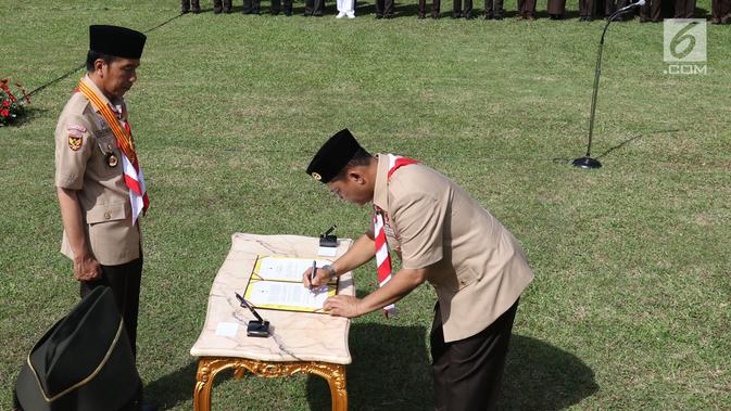 Komjen Pol (Purn) Budi Waseso menandatangani dokumen pelantikan Ketua Kwarnas Gerakan Pramuka periode 2018-2023 di halaman Istana, Kamis (27/12). Pelantikan menandai pergantian dari pengurus lama yang dipimpin Adhyaksa Dault. (Liputan6.com/Angga Yuniar)