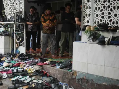 Sepatu dan sandal ditinggalkan di luar saat orang-orang melaksanakan salat Jumat di sebuah masjid, selama bulan suci Ramadan di Jakarta, Jumat 20 Februari 2026. Ribuan umat muslim di Indonesia melaksanakan ibadah salat Jumat pertama pada Ramadan 1447 Hijriah. (AP Photo/Dita Alangkara)