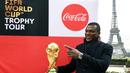 Mantan bek Prancis, Marcel Desailly berpose dengan trofi Piala Dunia dengan latar menara Eiffel selama FIFA World Cup Trophy Tour di Paris (20/3). Piala Dunia 2018 diselenggarakan 14 Juni dan 15 Juli 2018 di Rusia. (AFP Photo/Franck Fife)