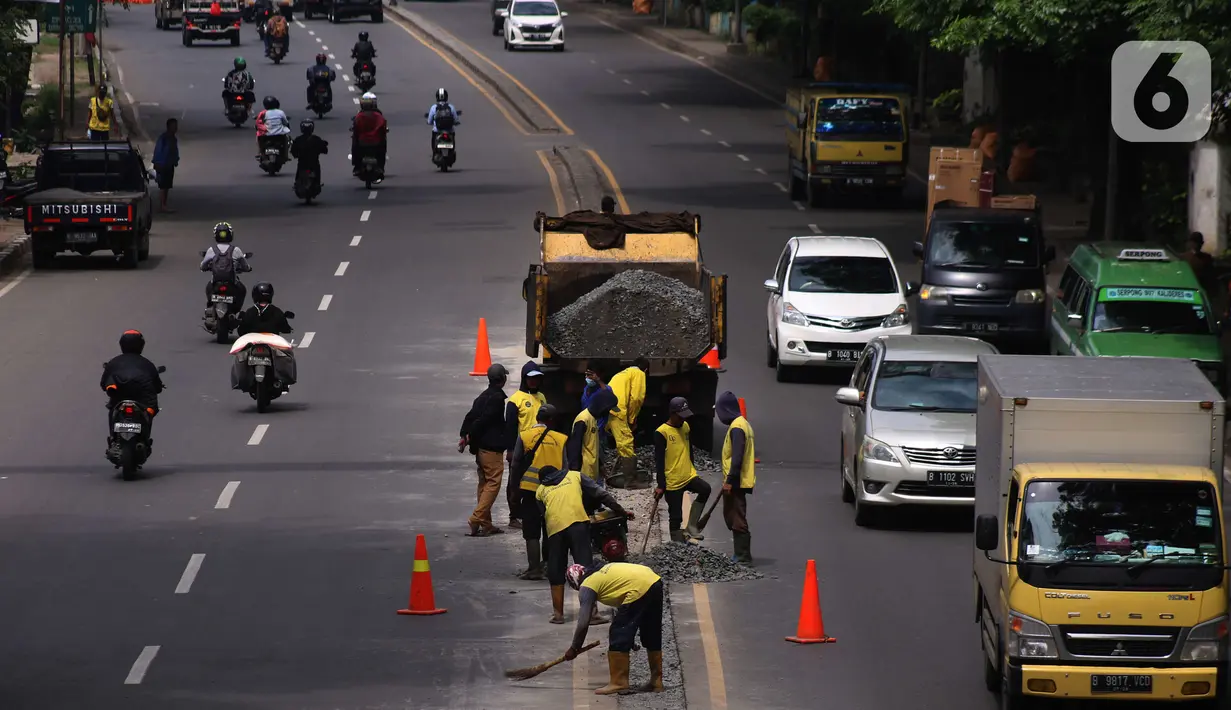 Pekerja melakukan penataan di ruas jalan nasional di Jalan Daan Mogot, Kota Tangerang, Banten, Selasa (15/2/2022). Pemkot Tangerang berencana melakukan sistem satu arah di Jalan Daan Mogot untuk mengatasi kemacetan di akses masuk tol Cengkareng-Batu Ceper-Kunciran. (Liputan6.com/Angga Yuniar)