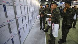 Tentara Korea Selatan membaca informasi pekerjaan saat mengikuti job fair di ruang pameran KINTEX, Goyang, Korea Selatan, Rabu (20/3). Job fair bagi para tentara ini dgelar setiap tahun. (JUNG Yeon-Je/AFP)