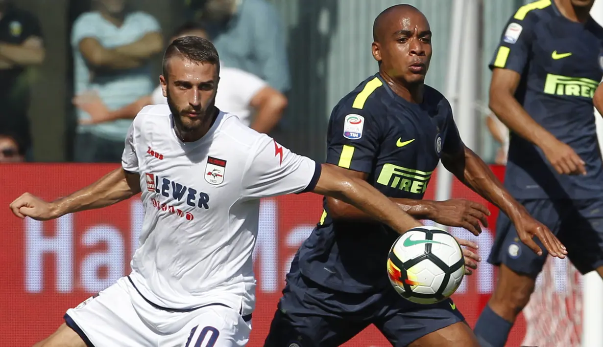 Gelandang Inter Milan, Joao Mario, berebut bola dengan gelandang Crotone, Andrea Barberis, pada laga Serie A Italia di Stadion Ezio Scida, Calabria, Sabtu (16/9/2017). Crotone kalah 0-2 dari Inter. (AFP/Carlo Hermann)