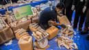 Petugas membongkar kotak berisi potongan gading di bandara Bangkok, Selasa (7/3). Thailand telah menyita lebih dari 300 kilogram gading dari Malawi pada penerbangan ke bandara utama ke Bangkok. (AFP PHOTO / Roberto SCHMIDT)