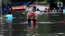 Warga melintasi banjir yang merendam perumahan Villa Mutiara Pluit, Tangerang, Banten, Senin (3/2/2020). Banjir disebabkan jebolnya tanggul sungai di sekitar kawasan tersebut. (merdeka.com/Magang/Muhammad Fayyadh)