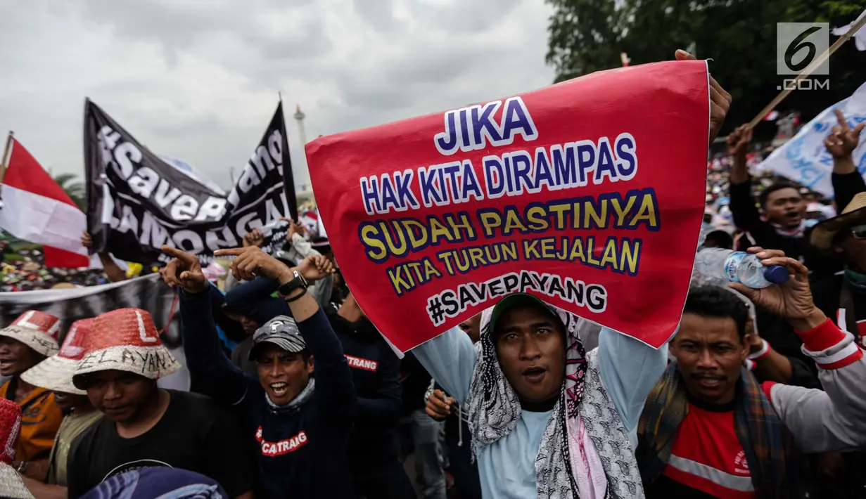 Nelayan membentangkan spanduk dalam unjuk rasa di depan Istana Negara, Jakarta Pusat, Rabu (17/1). Ada sekitar 30 ribu nelayan yang dilaporkan mengikuti aksi tersebut. (Liputan6.com/Faizal Fanani)