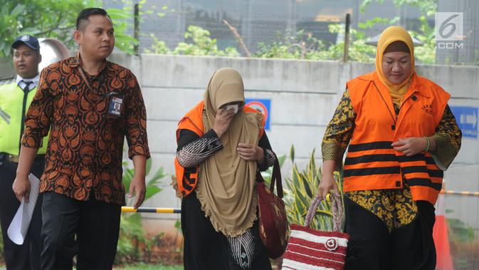 Tersangka Anggota DPRD Kota Malang Asia Iriani (kanan) dan Een Ambarsari (tengah) tiba di Gedung KPK, Jakarta, Rabu (21/11). Keduanya banyak menunduk saat tiba di Gedung KPK. (Merdeka.com/Dwi Narwoko)