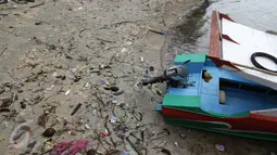 Sebuah perahu motor tengah bersandar di pinggir dermaga yang dipenuhi sampah di Pulau Bunaken, Manado, Sabtu (17/12). Banyak wisatawan mengeluhkan keberadaan sampah, terutama sampah plastik yang dirasa sudah sangat menganggu. (Liputan6.com/Fery Pradolo)