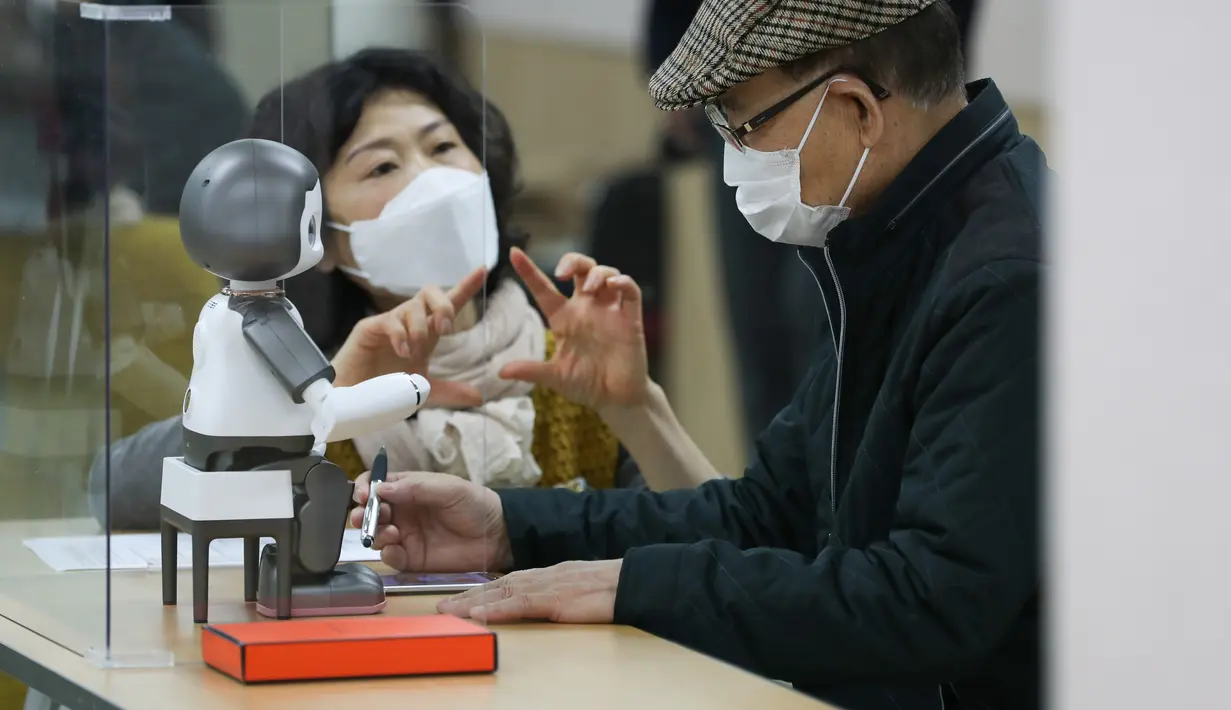 Seorang instruktur (kiri) program pendidikan membantu seorang partisipan mempelajari LIKU, fasilitator pengajaran robotik, di sebuah pusat kesejahteraan warga lanjut usia (lansia) di Distrik Yangcheon, Seoul, Korea Selatan (16/11/2020). (Xinhua/Wang Jingqiang)