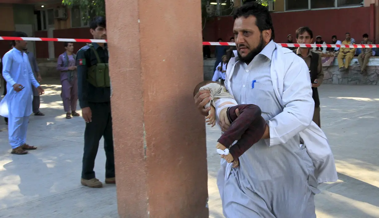 Seorang lelaki berlari membawa seorang anak yang menjadi korban gempa di Jalalabad, Afghanistan, Senin (26/10/2015). Sekitar 43 orang dipastikan tewas akibat lindu berkekuatan 7,5 skala Richter tersebut. (REUTERS/Parwiz)