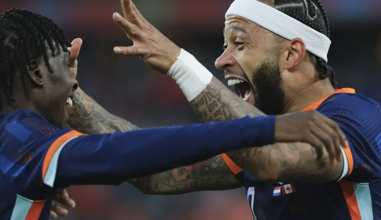 Penyerang Belanda Memphis Depay berselebrasi dengan Jeremie Frimpong setelah mencetak gol pertama timnya ke gawang Kanada pada laga uji coba menjelang EURO 2024 di De Kuip, Feyenoord, Jumat (7/6/2024) dini hari WIB. (AP Photo/Patrick Post)