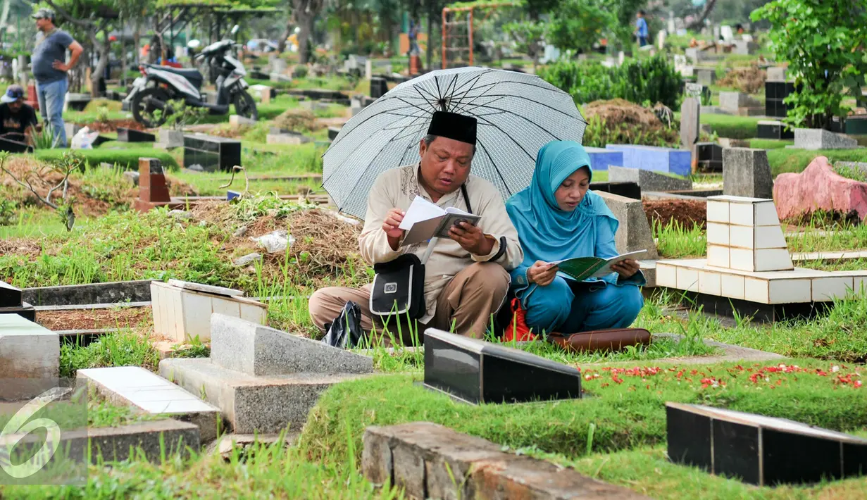 Warga membacakan doa di makam keluarganya menjelang bulan puasa di TPU Karet Bivak, Jakarta, Minggu (29/5/2016). Jelang bulan Ramadan, umat Muslim mulai ramai berziarah ke makam keluarganya. (Liputan6.com/Yoppy Renato)