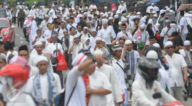 Puluhan orang berjalan kaki menuju Monas dari arah Tanah Abang, Jakarta, Jumat (2/12). Mereka terlihat berbondong-bondong berjalan untuk mengikuti demo 2 Desember di Lapangan Monas. (Liputan6.com/Helmi Afandi)