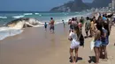 Pengunjung mengambil gambar bangkai paus bungkuk yang terdampar di tepi pantai Ipanema, Rio de Janeiro, Rabu (15/11). Diketahui bahwa pantai di sepanjang Brasil memang kerap menjadi pantai bermigrasi bagi paus. (AFP PHOTO / Leo Correa)