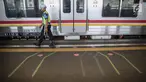 Petugas berjaga di garis antrean penumpang saat menunggu KRL di Stasiun Juanda, Jakarta, Kamis (10/8). PT KAI Commuter Jabodetabek melakukan uji coba garis antrean penumpang tersebut guna untuk keselamatan bagi para penumpang. (Liputan6.com/Faizal Fanani)