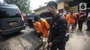 Polisi menggiring tersangka saat pemusnahan barang bukti narkotika di Jakarta, Rabu (24/8/2022). Narkotika tersebut merupakan hasil penyitaan dari 13 kasus. (Liputan6.com/Faizal Fanani)