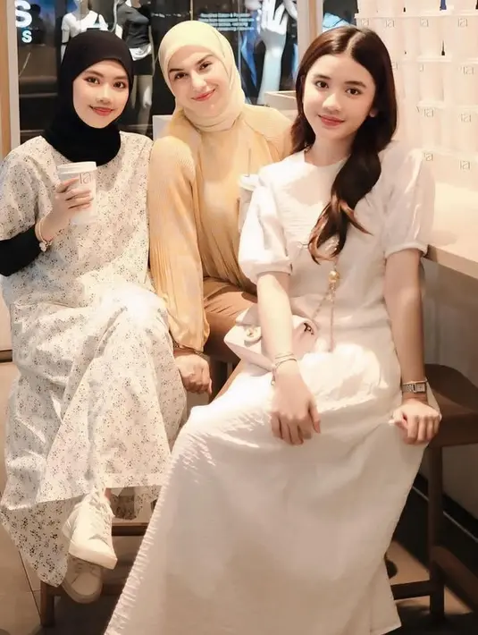 Irish Bella bersama suami dan anak sambungnya memilih liburan ke Thailand, Bangkok. Tampak Irish Bella mengenakan atasan warna coklat dipadukan kerudung dan celana warna senada. [@_irishbella_]