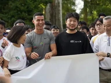 Pemain sepak bola asal Portugal, Cristiano Ronaldo (tengah) ambil bagian dalam acara untuk mendukung beasiswa pemuda yang didirikan oleh filantropis Peter Lim di Singapura, Jumat (2/6/2023). (Nicholas Yeo/AFP)