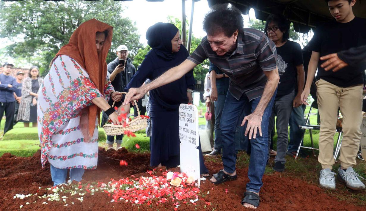 Vokalis grup band God Bless, Ahmad Albar, menabur bunga di atas makam Donny Fattah di Tempat Pemakaman Umum (TPU) Kampung Kandang, Jagakarsa, Jakarta Selatan, Sabtu (7/3/2026). Salah satu pilar musik rock Indonesia yang juga bassis sekaligus pendiri band legendaris God Bless, Donny Fattah meninggal dunia. (Kapanlagi.com/Budy Santoso)