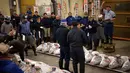 Calon pembeli menawar ikan tuna beku selama pelelangan pertama tahun ini di Pasar Tsukiji di Tokyo (5/1). Lelang ikan dengan harga mencapai miliaran rupiah ini rutin digelar setiap awal tahun. (AP Photo / Eugene Hoshiko)