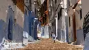 Seorang anak berjalan disebuah anak tangga di Kota Chefchaouen, Maroko, Minggu (1/5). Chefchaouen baru-baru ini dinobatkan sebagai kota terindah keenam dari 50 kota di dunia menurut Conde Nast Traveler. (FADEL SENNA / AFP)