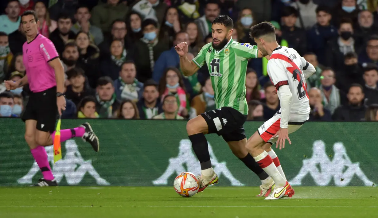 Gelandang Real Betis, Nabil Fekir (kiri) berusaha melewati gelandang Rayo Vallecano, Oscar Valentin pada semifinal Copa del Rey di Stadion Benito Villamarin, Spanyol (4/3/2022). Hasil imbang itu membuat Real Betis lolos ke babak final dengan agregat kemenangan 3-2. (AFP/Cristina Quicler)