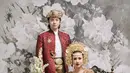 Shenina tampil menawan dengan suntiang megah khas Minang, kebaya merah marun beraksen emas, serta kain songket yang melengkapi tampilan tradisionalnya. Angga pun tampil gagah dengan setelan adat Minang berwarna senada, dipadukan dengan jas motif ukiran dan destar yang mencerminkan sosok pria Minang yang berkarisma. [@angga].