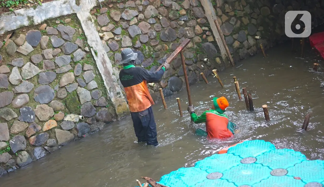 Petugas membuat jebakan sampah di Kali Pancoran, Jakarta, Kamis (12/11/2020). Jebakan sampah tersebut dibuat guna memermudah petugas saat membersihkan kali, terutama saat musim hujan. (Liputan6.com/Immanuel Antonius)