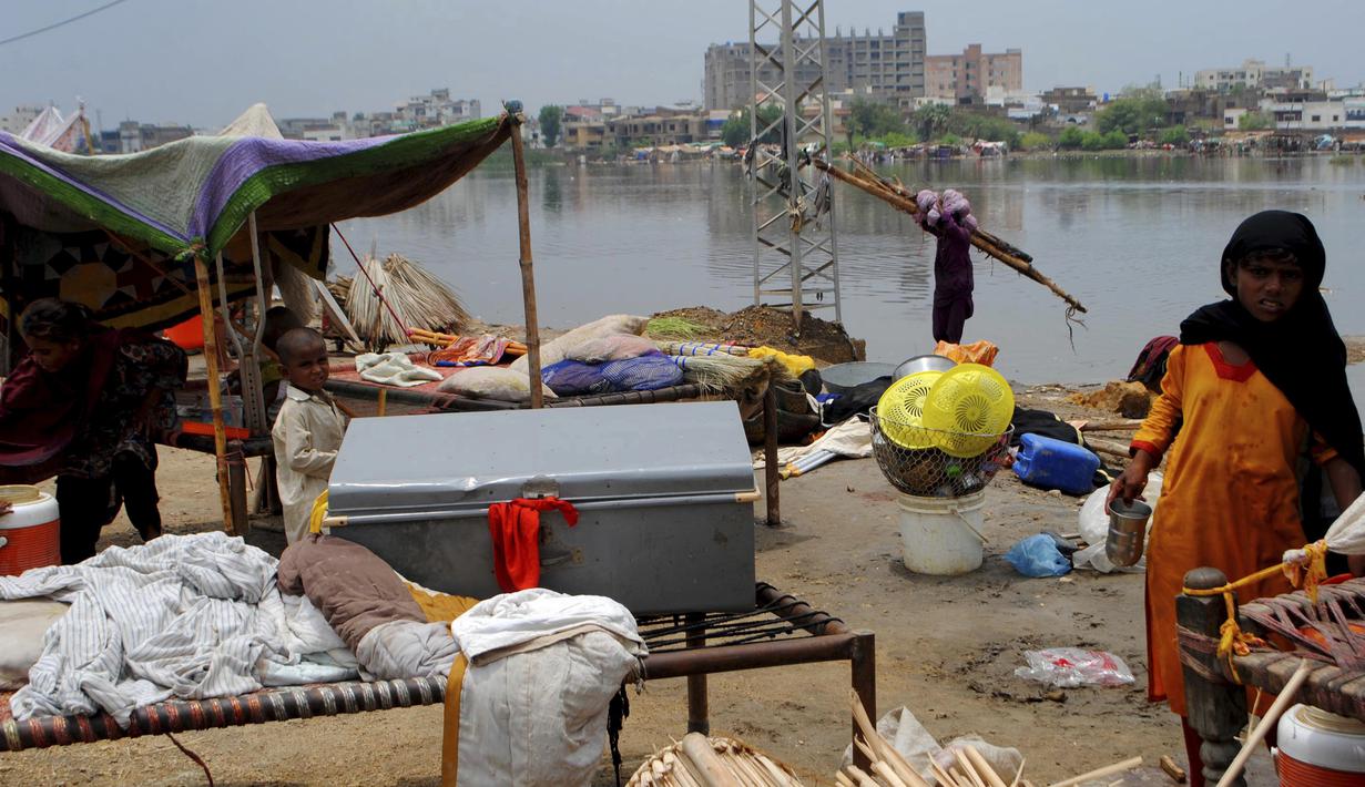 Warga yang tinggal di daerah dataran rendah berlindung di tepi sungai, di Hyderabad, Pakistan, Selasa (30/7/2019). Departemen Meteorologi Pakistan mengatakan bahwa hujan memasuki provinsi Sindh dari Rajasthan India dan memperkirakan hujan akan turun tiga hari lagi. (AP Photo/Fareed Khan)
