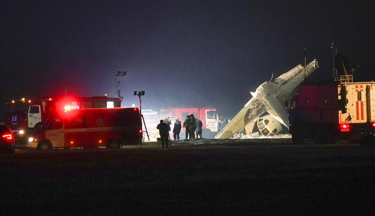 Pekerja darurat bekerja di samping pesawat Antonov An-26 yang jatuh di Bandara Almaty, Kazakhstan, Sabtu (13/3/2021). Menurut data awal, empat orang tewas dan dua orang yang mengalami luka-luka dilarikan untuk dirawat di rumah sakit. (AP Photo/Vladimir Tretyakov)