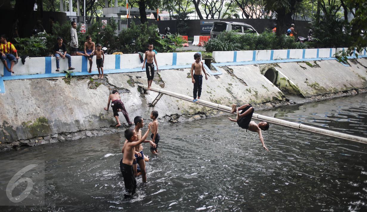Keceriaan saat anak-anak bermain di aliran Kali Gresik di Jalan Muhammad Yamin, Menteng, Jakarta, Minggu (26/2). Kondisi kali di Kota Jakarta yang bersih dan terawat mendapatkan respon positif bagi warga Ibu Kota. (Liputan6.com/Faizal Fanani)