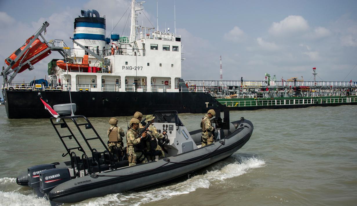 Anggota TNI AL mengawal kapal berbendera Singapura ke pelabuhan Surabaya, Jawa Timur, 10/5). Sembilan tersangka diduga melakukan pembajakan terhadap kapal tanker berbendera Singapura di perairan Tanjung Puting, Kalimantan. (AFP PHOTO/JUNI KRISWANTO)