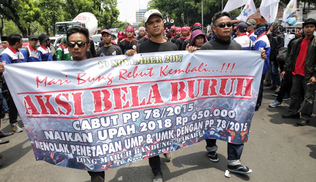 Massa buruh yang tergabung dalam Konfederasi Serikat Pekerja Indonesia (KSPI) membentangkan spanduk saat unjuk rasa di depan Balai Kota DKI Jakarta, Jumat (10/11). Para buruh mendesak Pemprov DKI merevisi UMP 2018 DKI Jakarta. (Liputan6.com/Faizal Fanani)