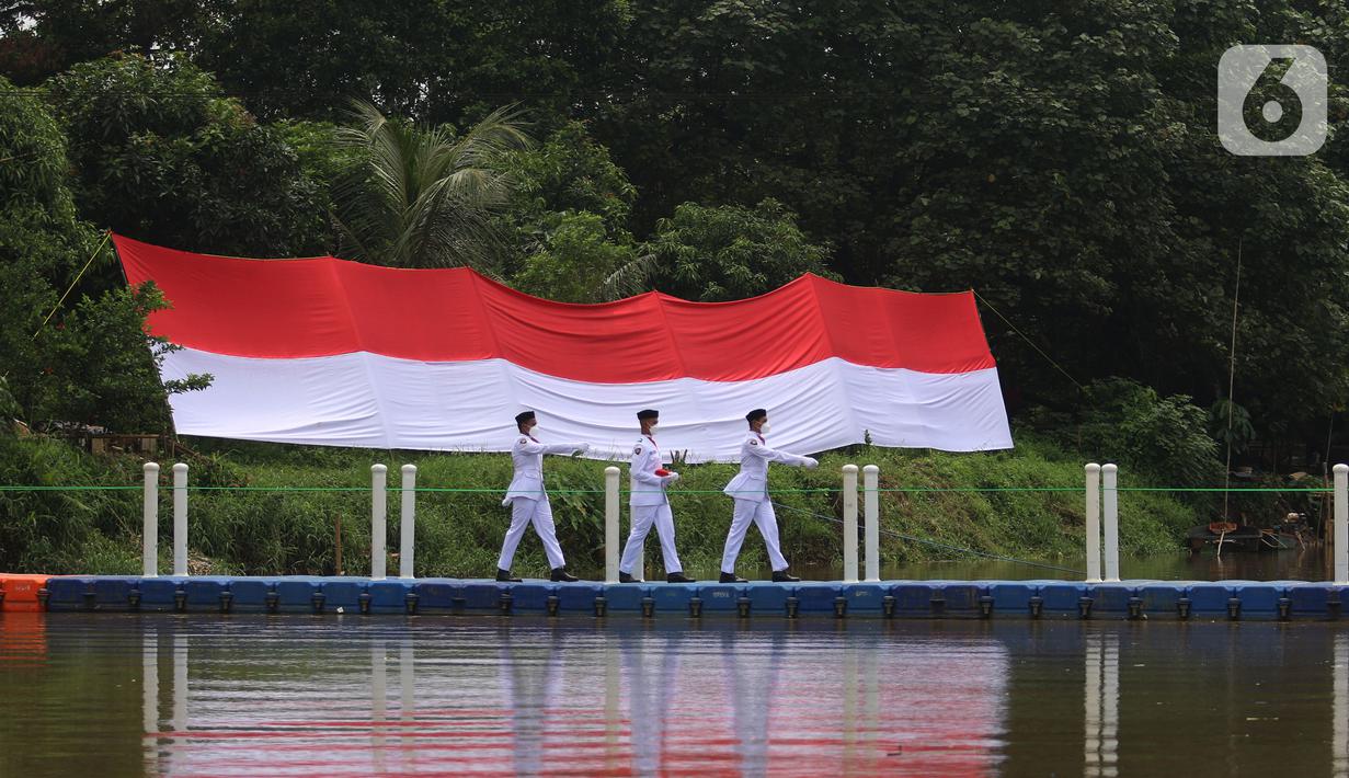 Anggota Paskibraka bersiap mengibarkan bendera merah putih di Sungai Cisadane, Kota Tangerang, Banten, Kamis (28/10/2021). Pengibaran bendera merah putih yang di ikuti puluhan pemuda tersebut di lakukan untuk memperingati hari sumpah pemuda. (Liputan6.com/Angga Yuniar)